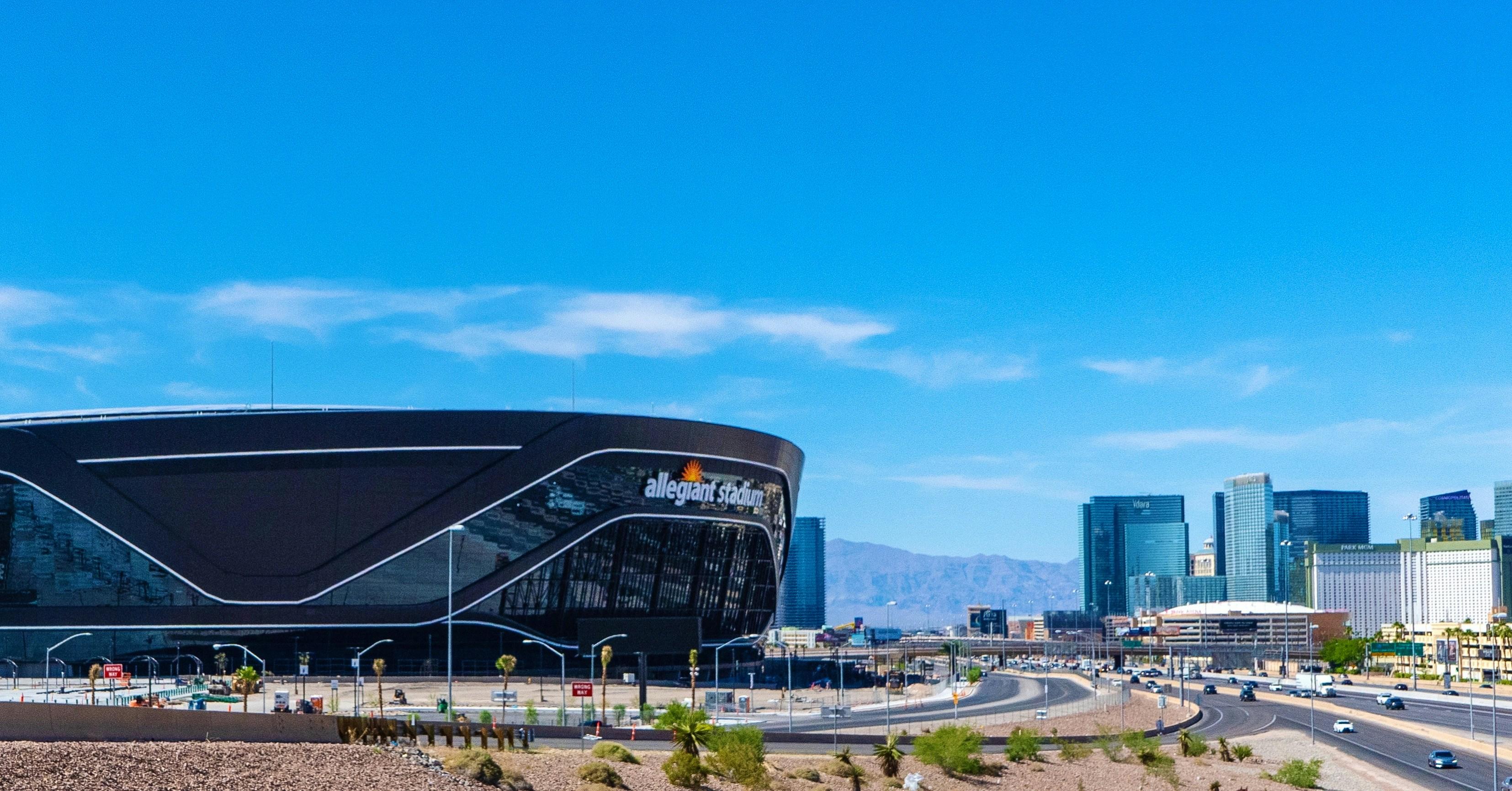 Allegiant Stadium in Las Vegas illuminated at night during a major Super Bowl event with crowds