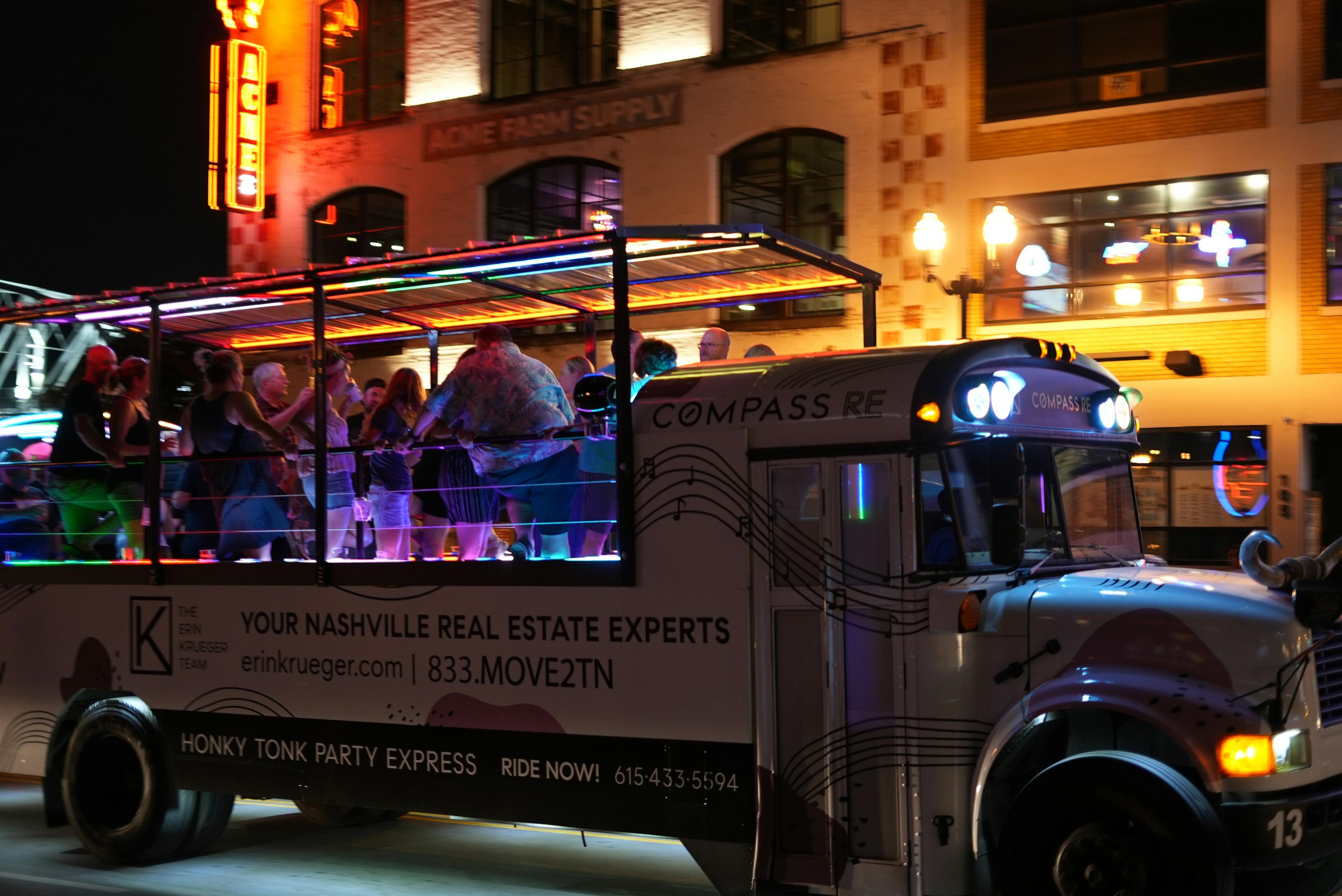 Interior of a luxury party bus with LED lighting and a group of friends celebrating New Year's Eve